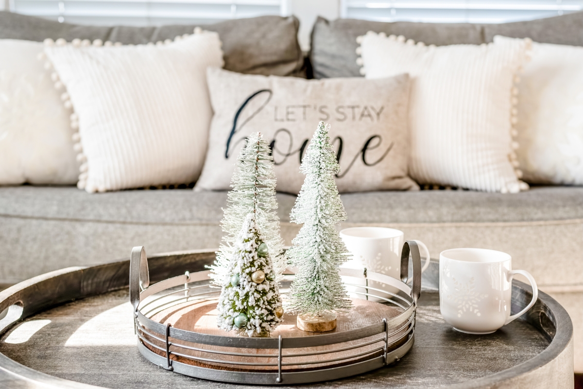Living room with minimal and layered holiday accents, including subtle ornaments, greenery, and candles for winter-ready decor.