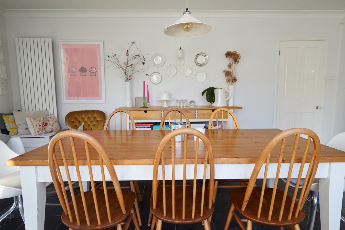Mixed seating dining room with eclectic dining chairs around wooden table 2026 trend