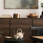 Modern living room showcasing mixed materials with a wooden coffee table, metal-framed sofa, and fabric cushions layered for texture and style