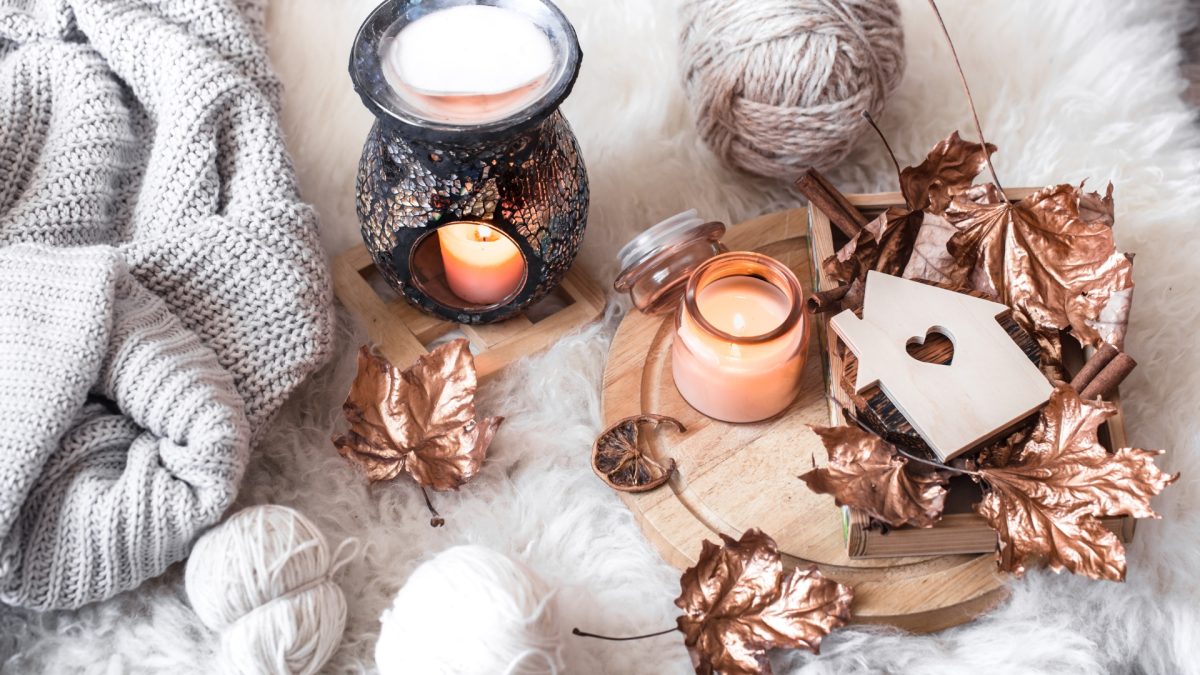 Cozy winter living room with layered blankets, warm lighting, and hygge-inspired decor elements.