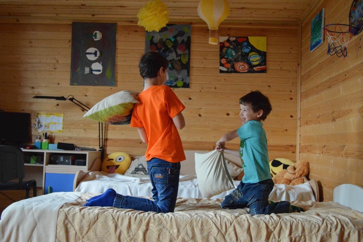 Montessori-inspired kids bedroom with child-level art display, low wall frames, soft neutral decor, and natural wood furniture promoting creativity