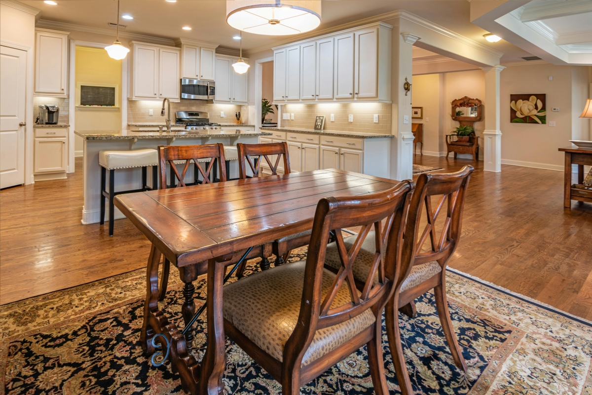 Dining table anchoring an open-concept dining area with modern furniture layout