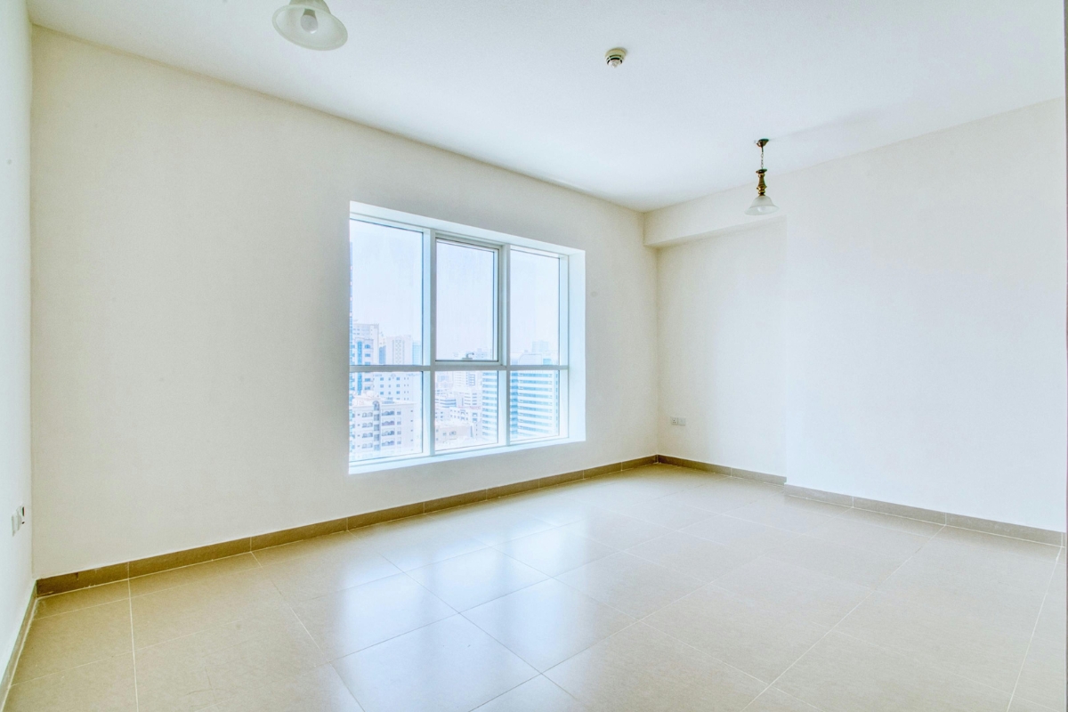 Person analyzing a living room for lighting, noting natural light, dark corners, and activity zones to plan day-to-night layered lighting.