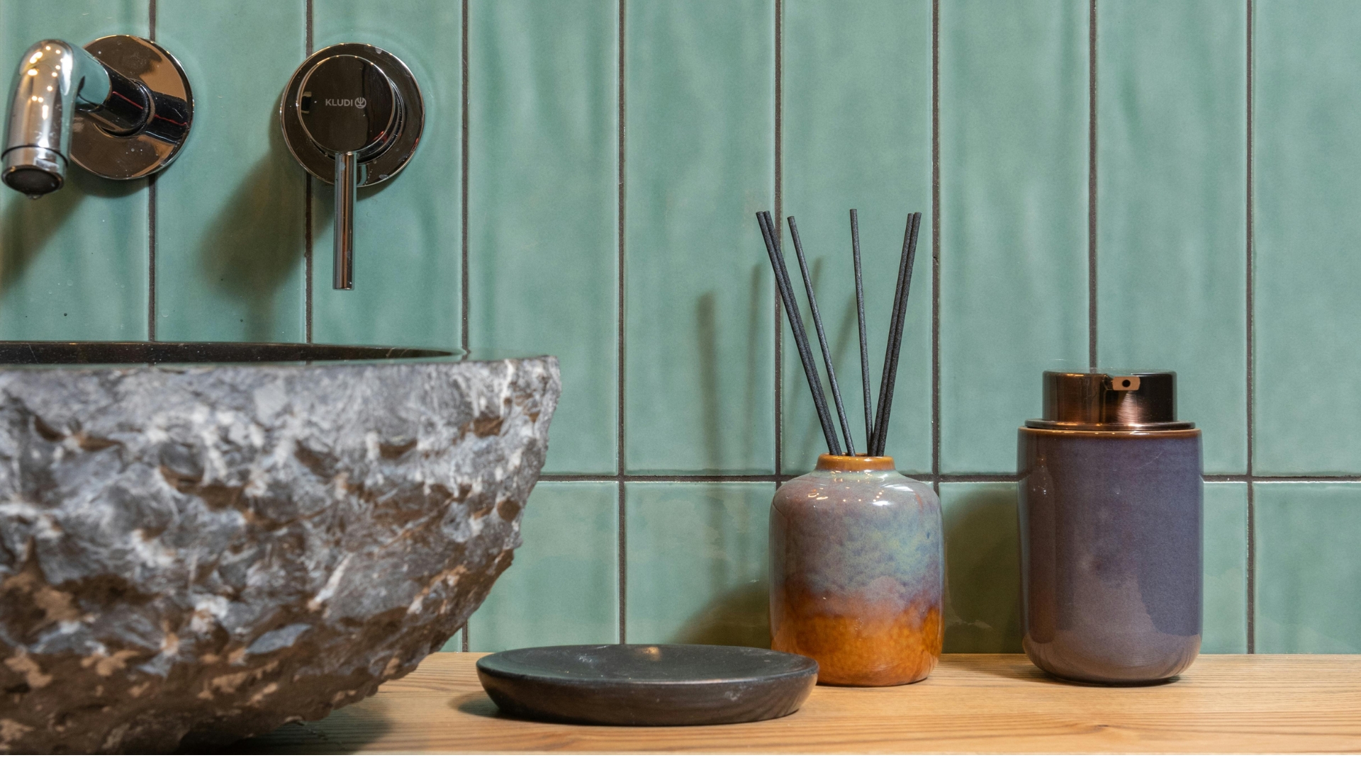Earth toned bathroom with wooden vanity and stone sink