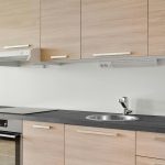 Functional kitchen wall decor with floating shelves, hanging hooks, and organized display creating a stylish and practical modern kitchen space