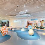 Imagination-driven kids room with interactive decor featuring chalkboard wall, reading corner, soft rug, toy storage, and creative play area for children