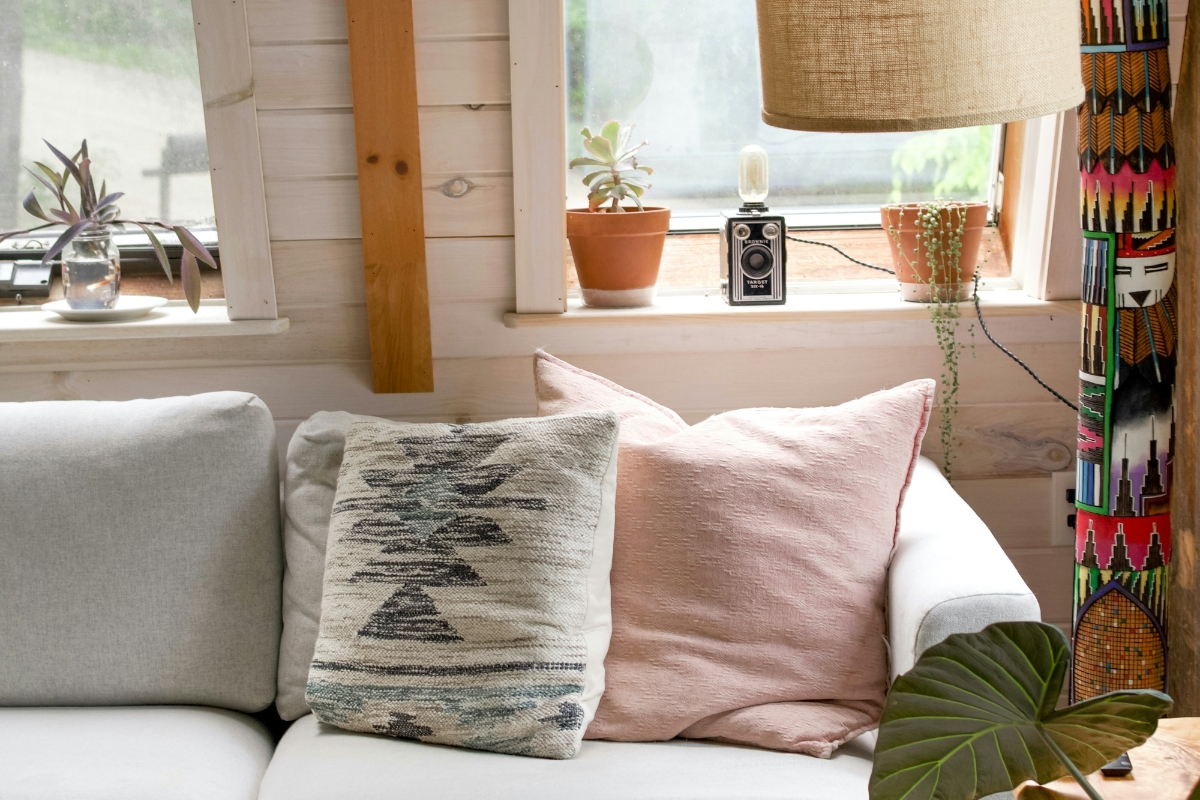 Living room with soft linen cushions, cotton throws, and light airy curtains creating a fresh, cozy, and spring-inspired home atmosphere.