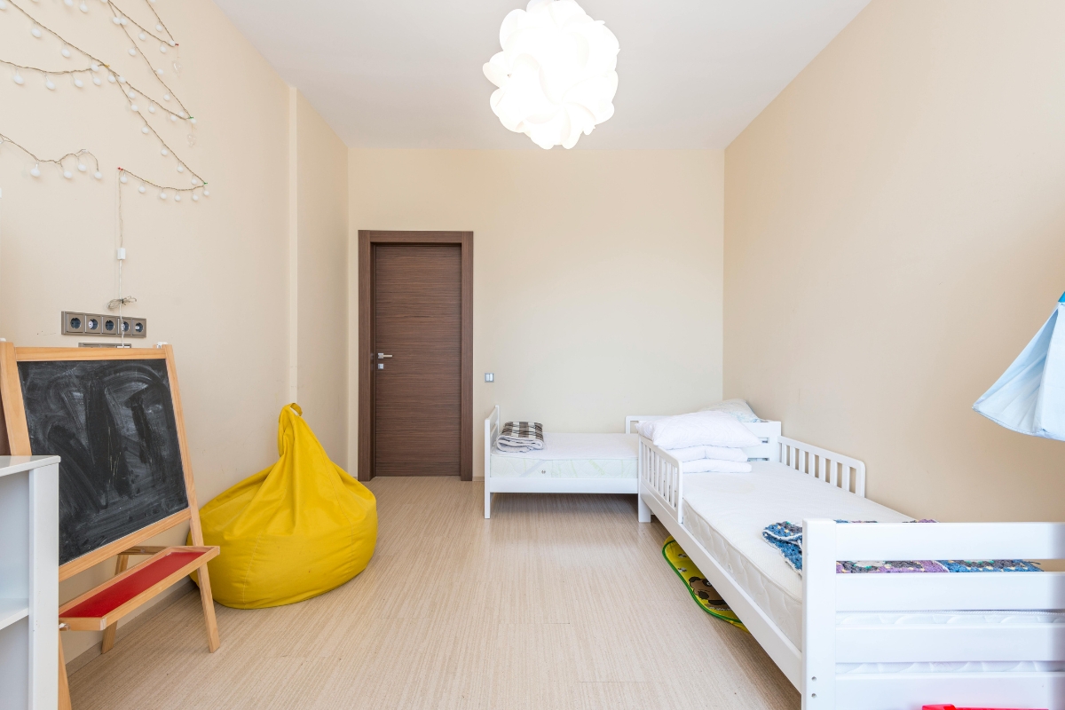 Modern kids room with a simple and functional layout featuring defined zones for sleep, play, and study, keeping the space organized and child-friendly