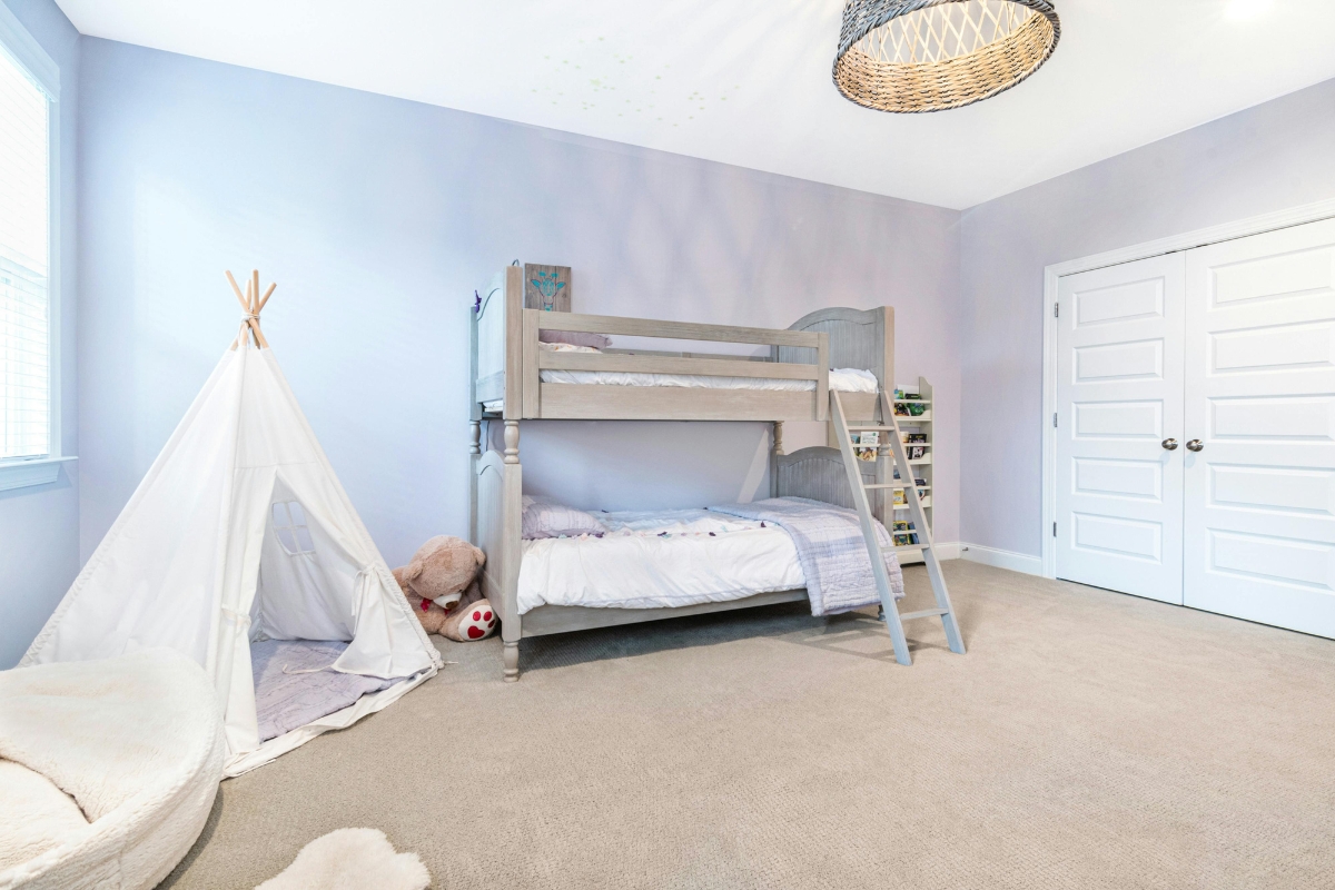 Kids room featuring layered soft textures including a plush rug, cushions, throws, and cozy bedding for a warm, comfortable, and child-friendly environment