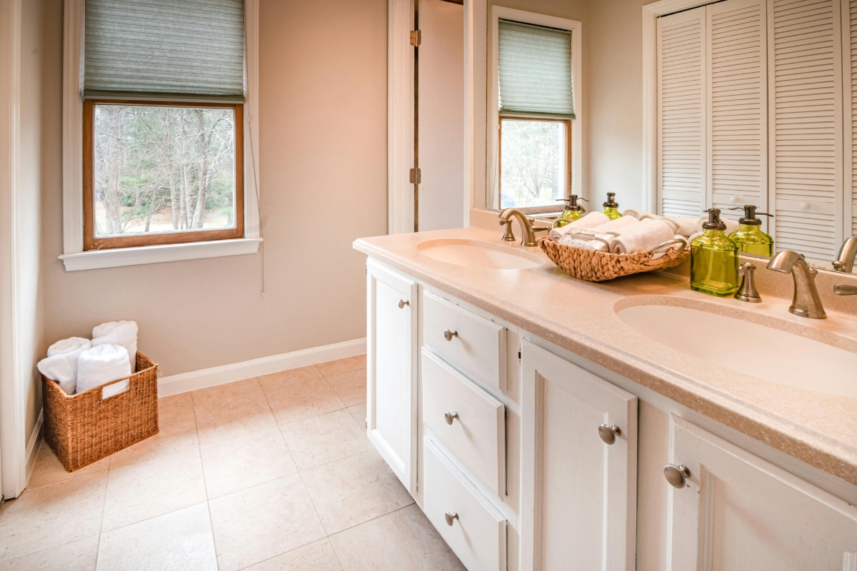 Minimal bathroom with textured towels, natural wood tray, and subtle accents