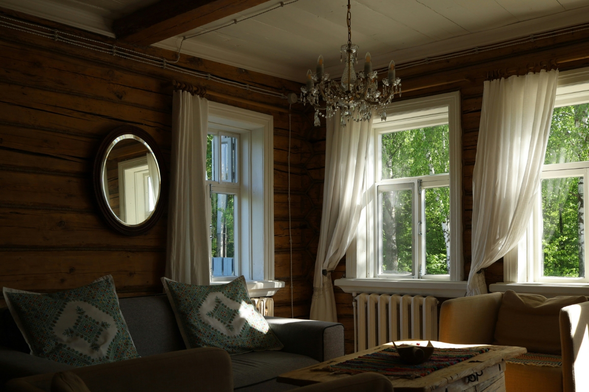 Living room with soft fall lighting featuring warm table lamps, glowing candles, and cozy ambient light creating a relaxing autumn home atmosphere