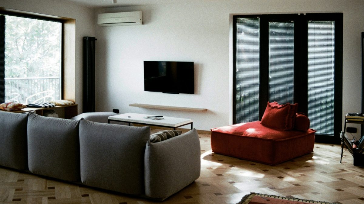 Airy summer living room with light curtains and neutral decor Heat-friendly summer home layout with natural light and minimal furniture