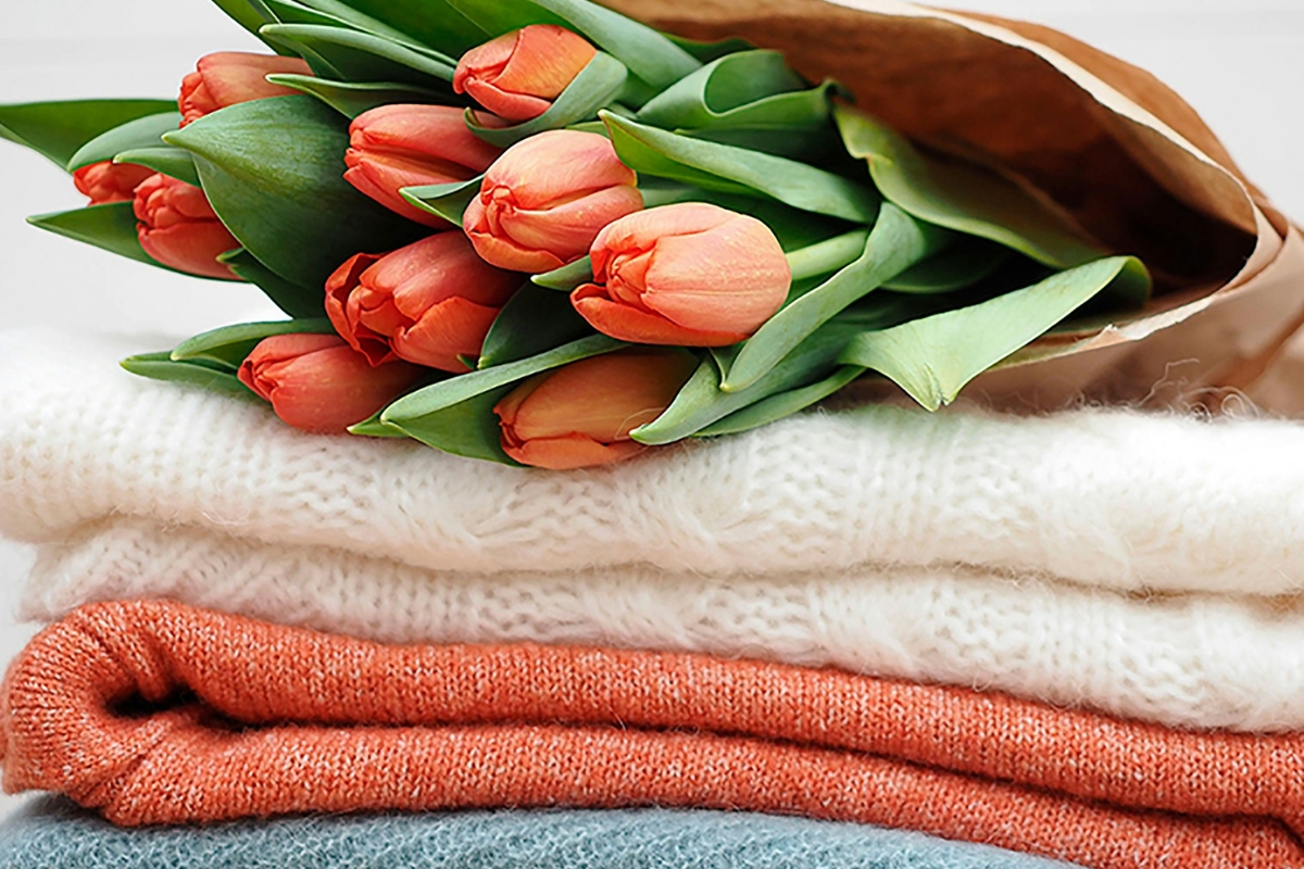 Bright living room styled with linen cushions, cotton throws, sheer curtains, and natural sunlight creating a soft, breathable spring home decor look.