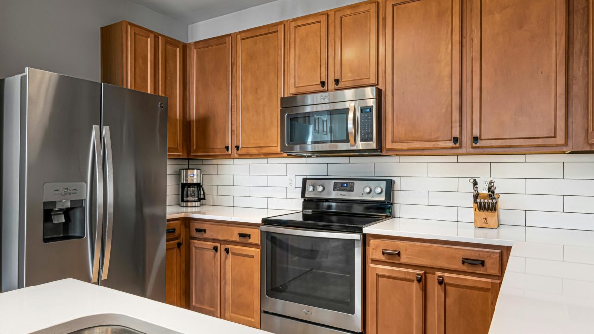 Textured kitchen wall with modern tiles and wooden panels creating a premium, stylish kitchen interior design look