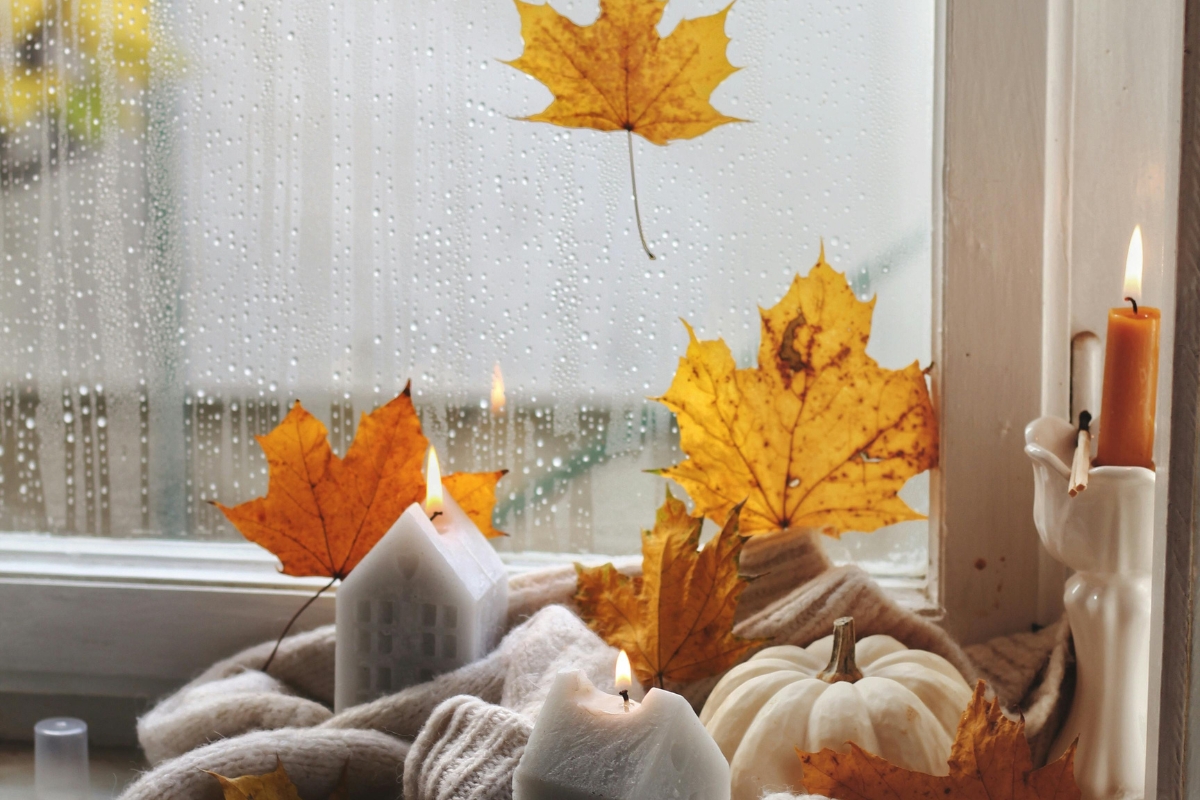 Living room styled with layered textures including velvet cushions, knitted throws, and soft rugs to create a cozy, touch-friendly autumn interior