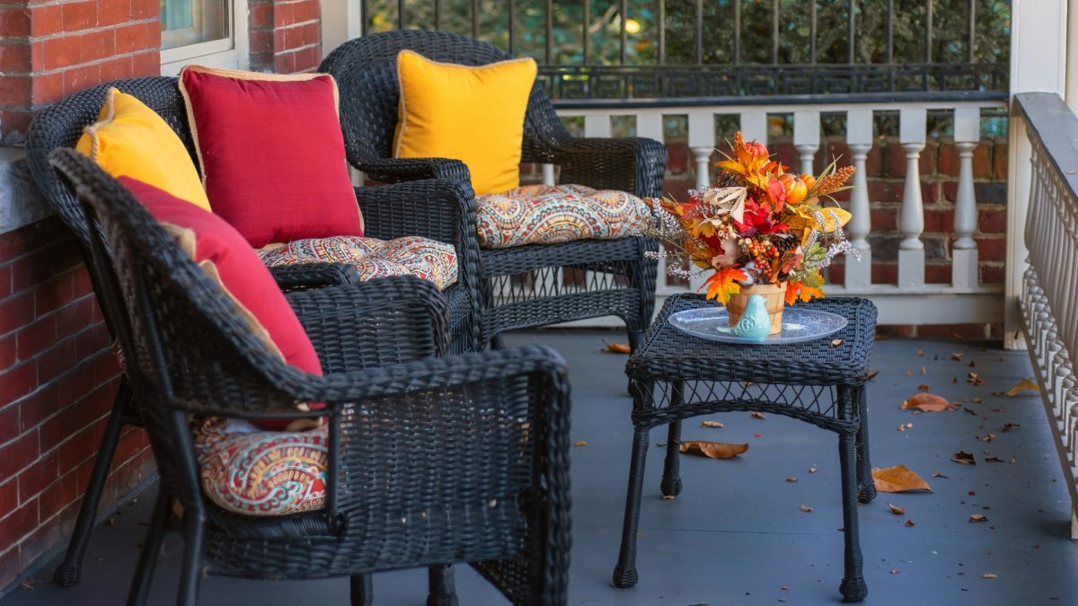 Living room transitioning from summer to fall decor with light neutral base, warm-toned cushions, soft throws, natural elements, and cozy lighting accents