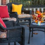Living room transitioning from summer to fall decor with light neutral base, warm-toned cushions, soft throws, natural elements, and cozy lighting accents