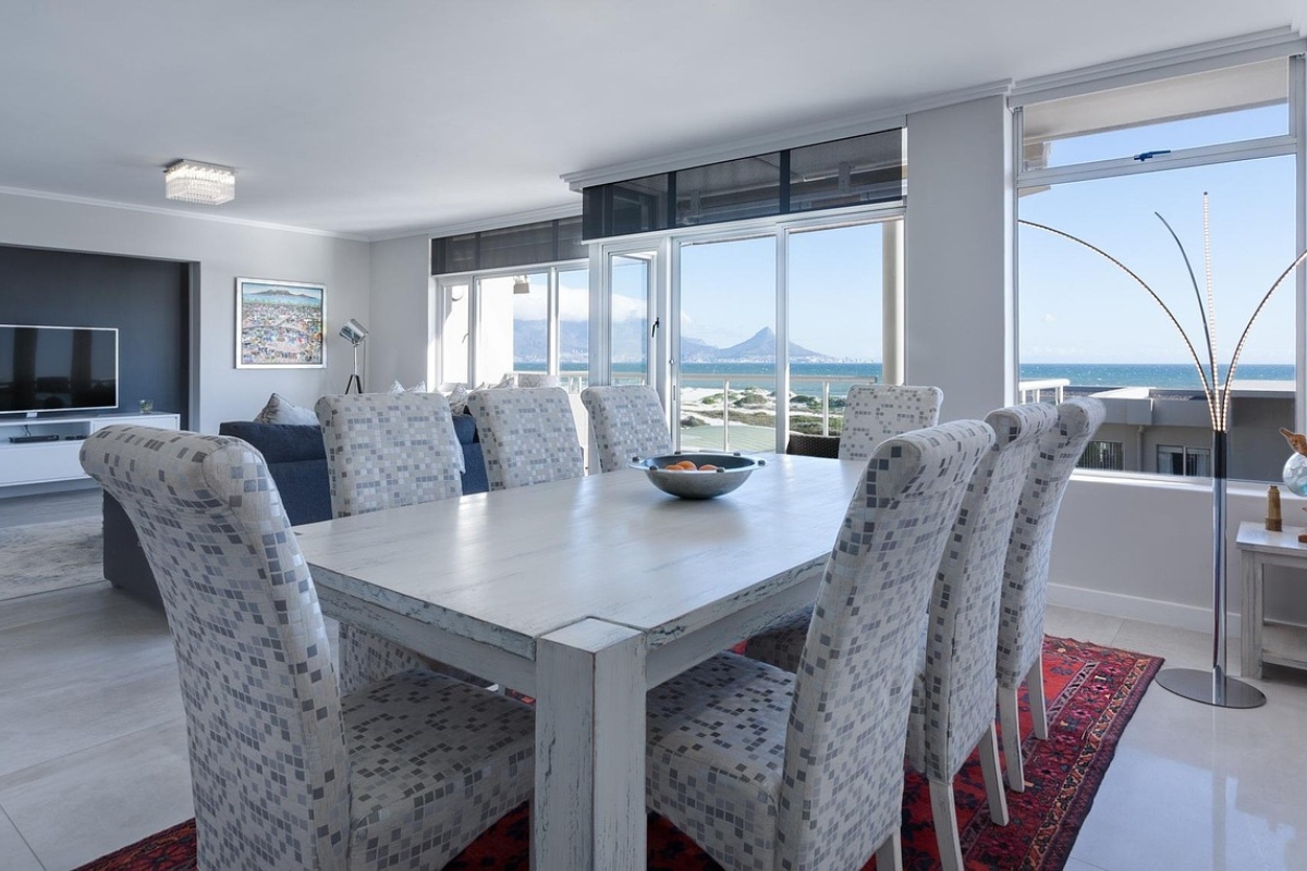 Modern curved dining table in a bright dining room with rounded chairs