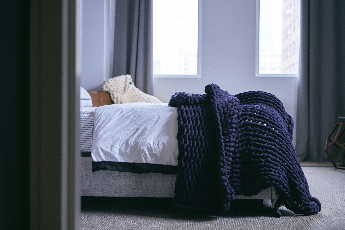 Bedroom styled with layered blankets, soft sheets, and cozy throws for winter