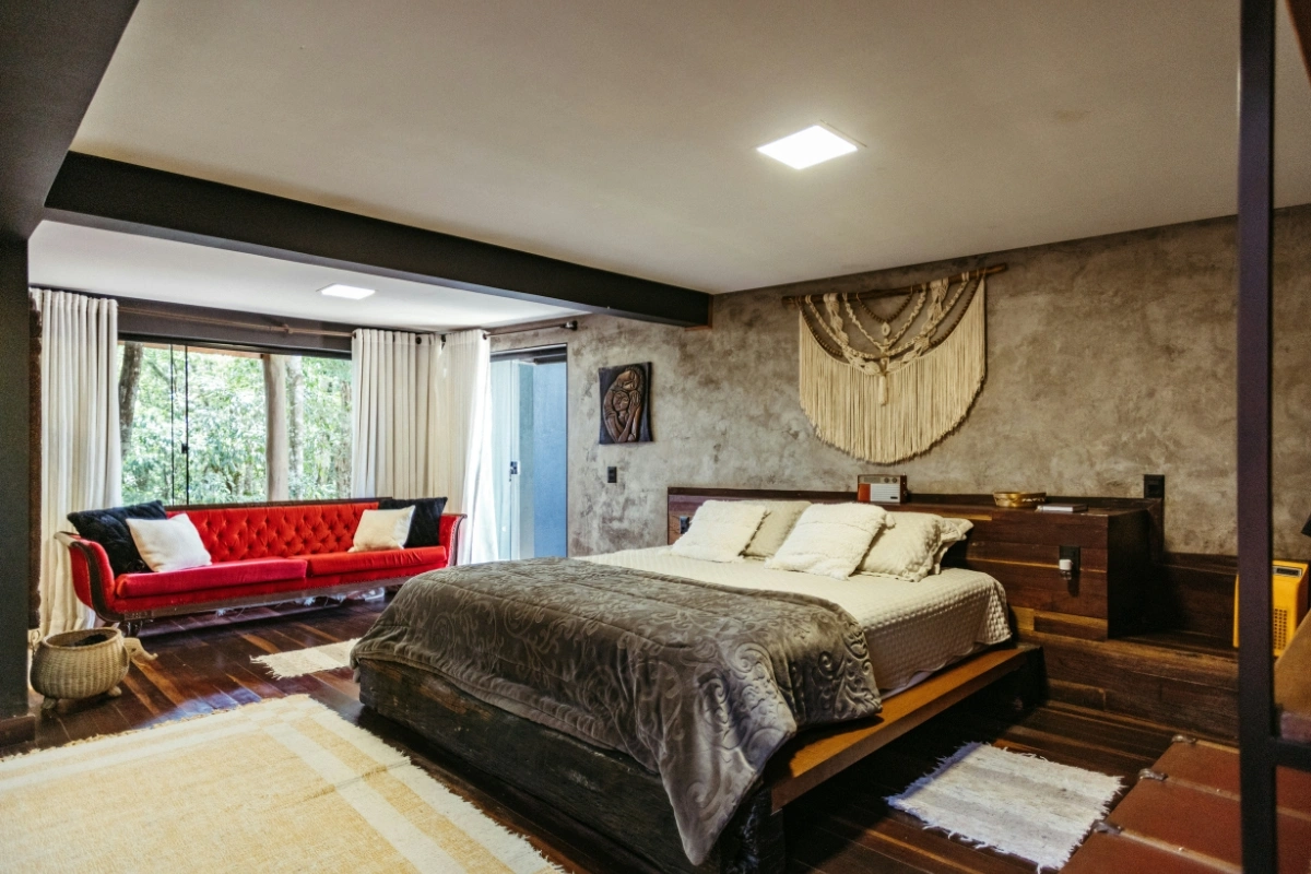 Bedroom brutalist interior with raw concrete walls, minimalist furniture, neutral tones, and dopamine decor accents for warmth and comfort