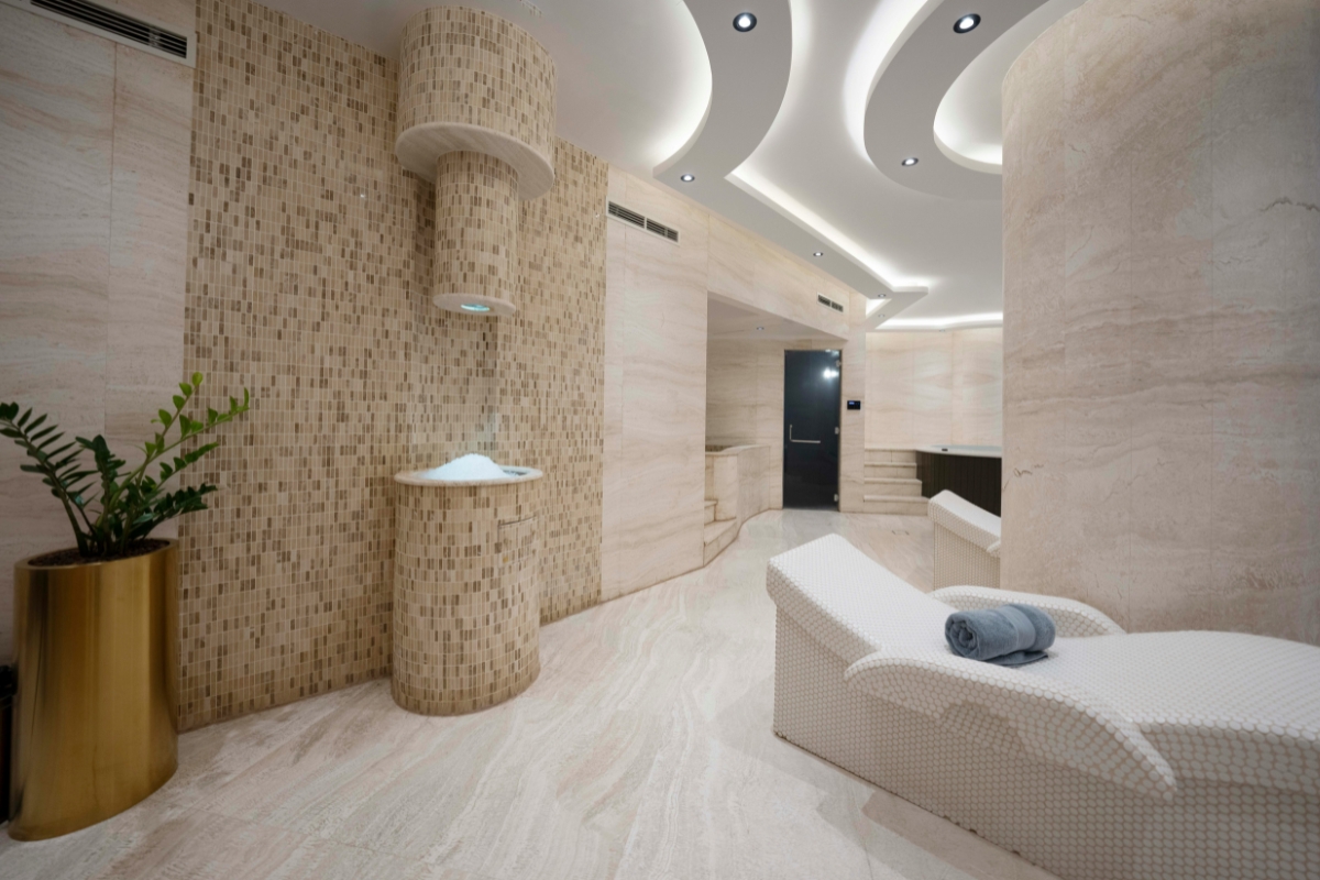 Biophilic interior design style living space with abundant indoor plants, natural wood furniture, stone textures, and large windows allowing natural light into a nature-inspired home.