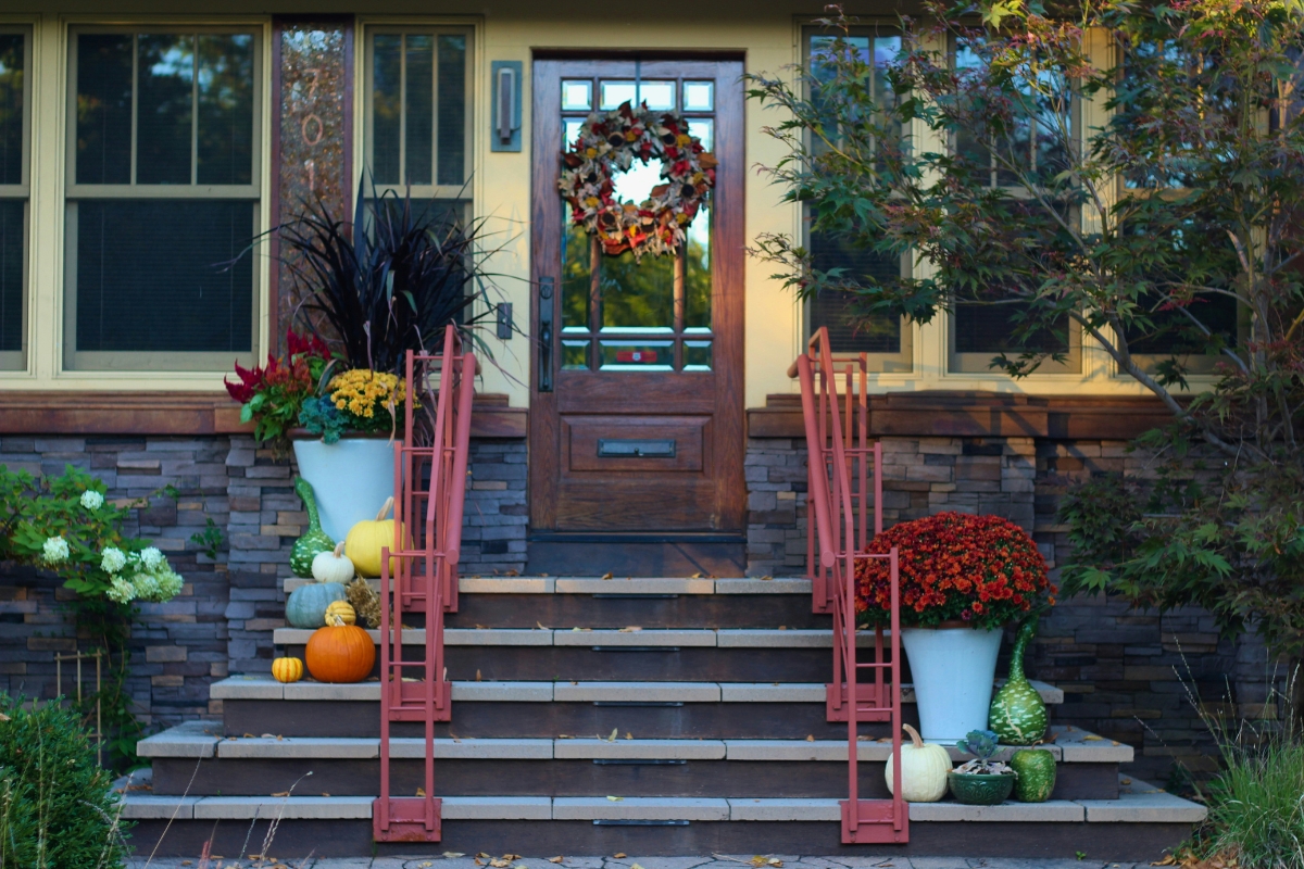 cozy fall front porch decorated with pumpkins and hay bales