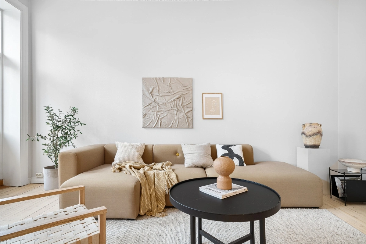 Quiet luxury designers showcasing interiors with oversized wall art in a modern elegant living room featuring high-end furniture and minimalist design